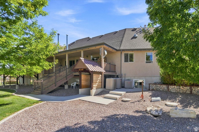 11290 South Southfield Road Mayfield, UT 84643 - Photo 20 of 103 Expansive covered patio with wood-finish decking and railings, leading to a gravel and concrete-paved yard