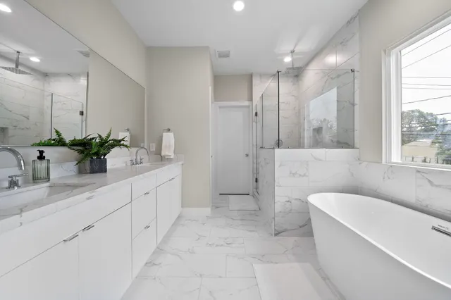 a bathroom with a double vanity sink a large mirror and shower