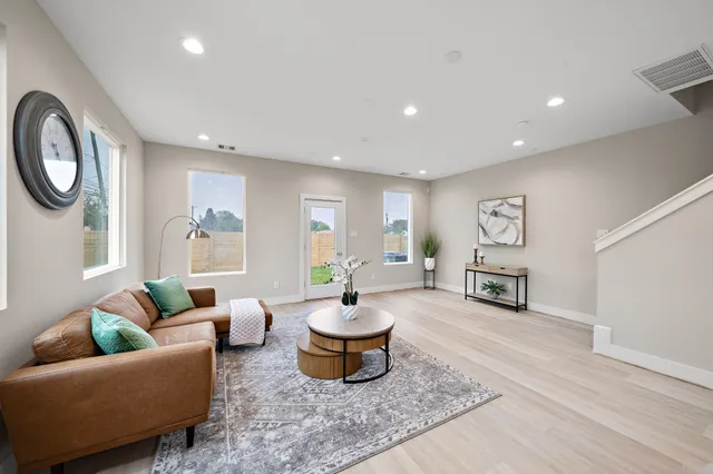 a living room with furniture and a wooden floor