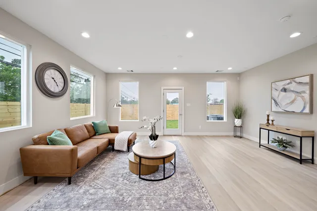 a living room with furniture a clock and a window