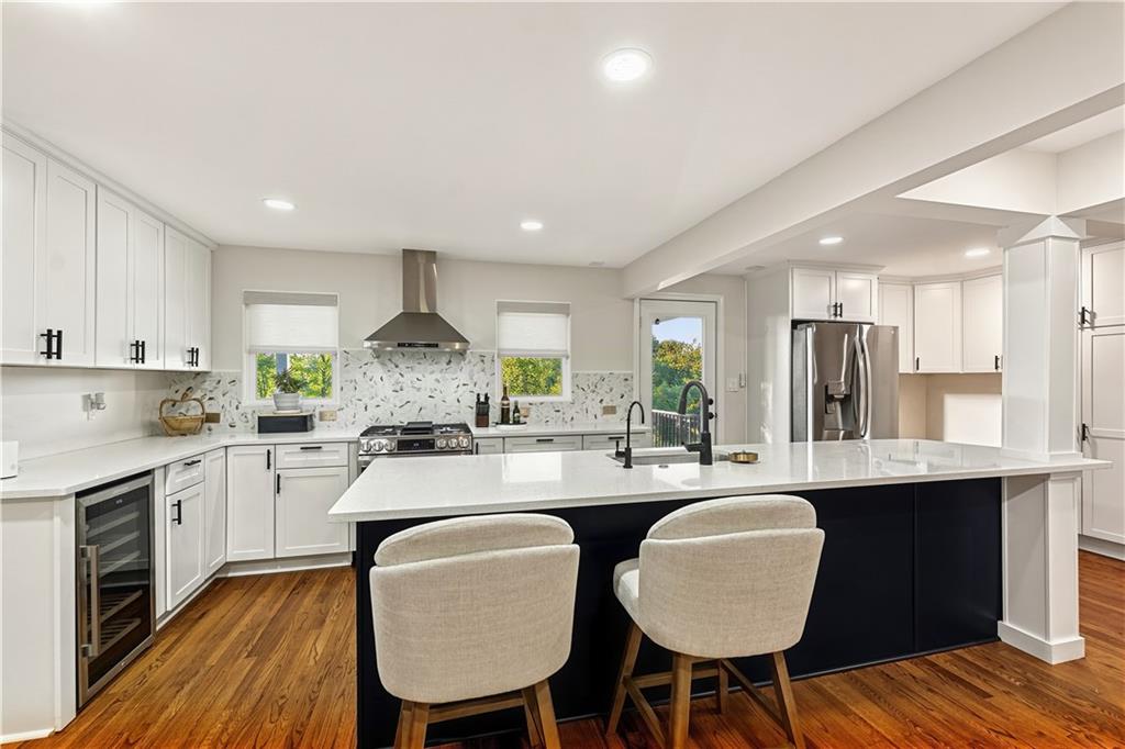 The updated kitchen is both stylish and functional featuring stainless appliances, gas stove, wine cooler, and more!