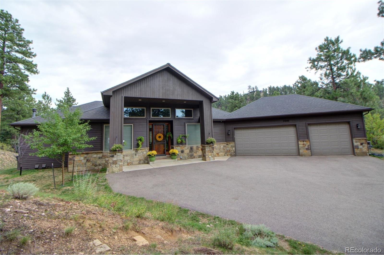 3095 South Piney Ridge Road Evergreen, CO 80439 - Photo 1 of 30 a front view of a house with garden