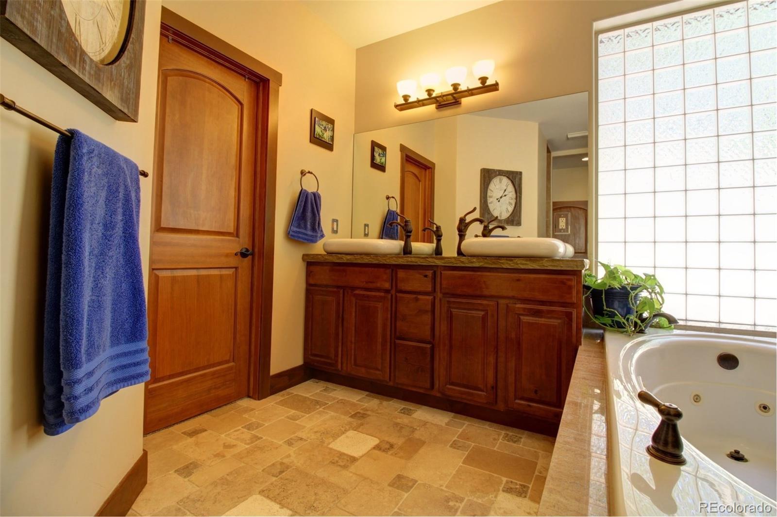 3095 South Piney Ridge Road Evergreen, CO 80439 - Photo 12 of 30 a bathroom with a tub sink and mirror