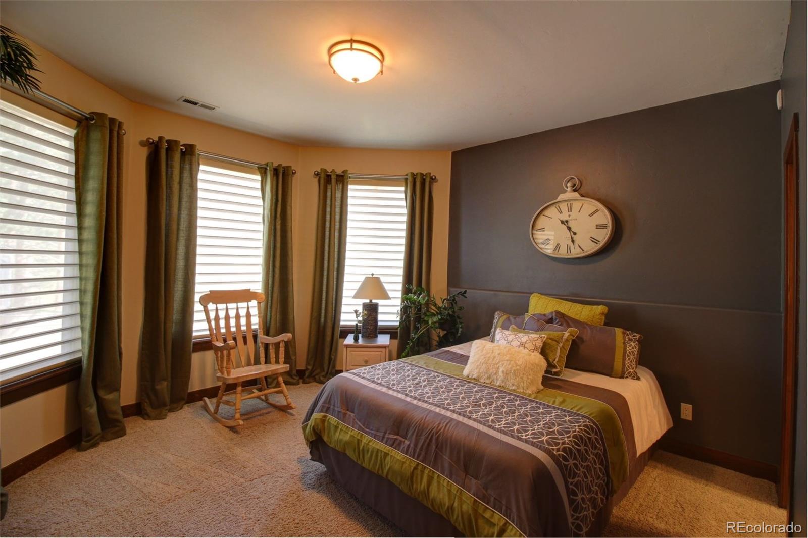 3095 South Piney Ridge Road Evergreen, CO 80439 - Photo 20 of 30 a bedroom with a bed and a large window