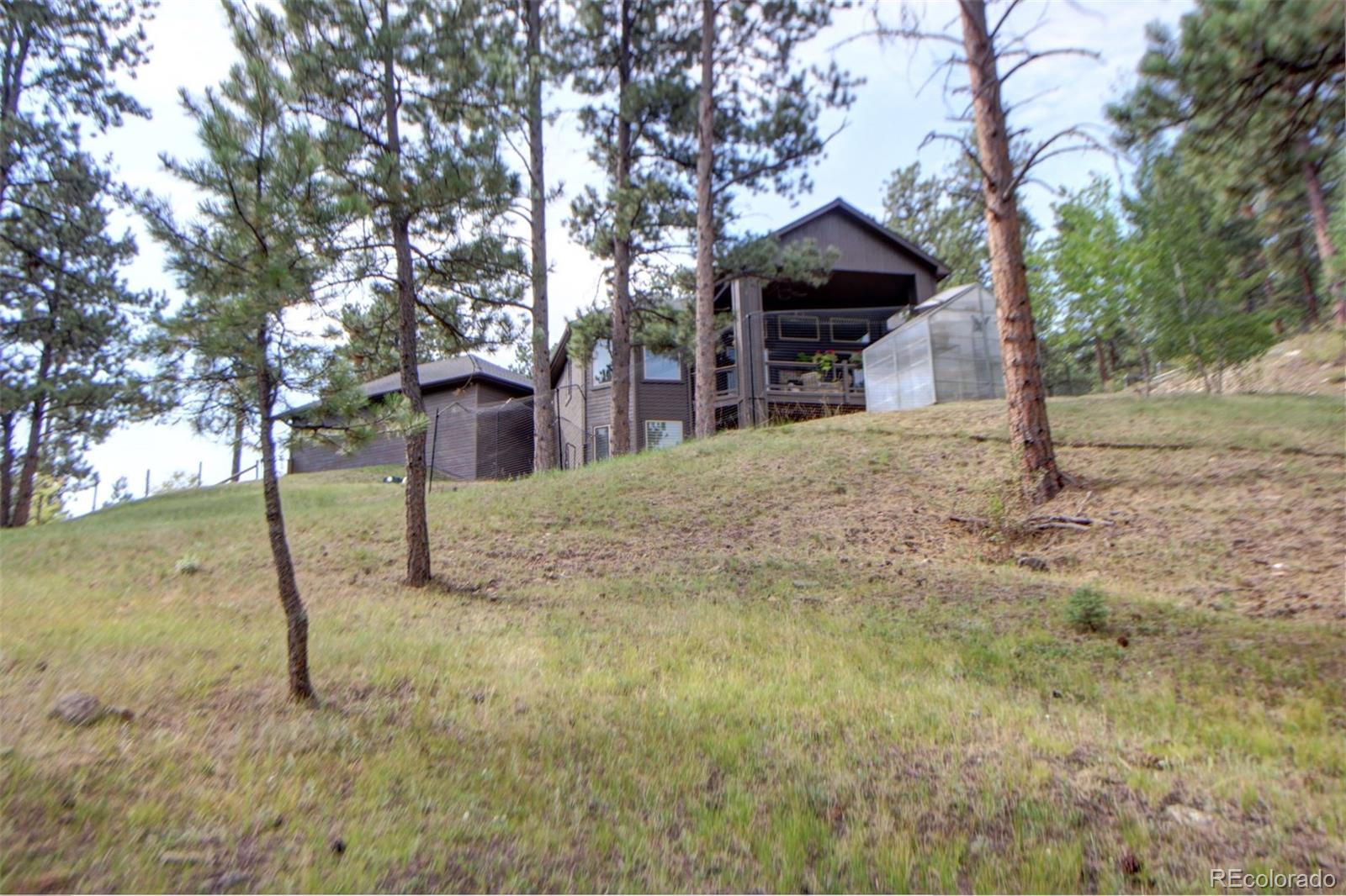 3095 South Piney Ridge Road Evergreen, CO 80439 - Photo 27 of 30 a front view of a house with a yard covered in snow