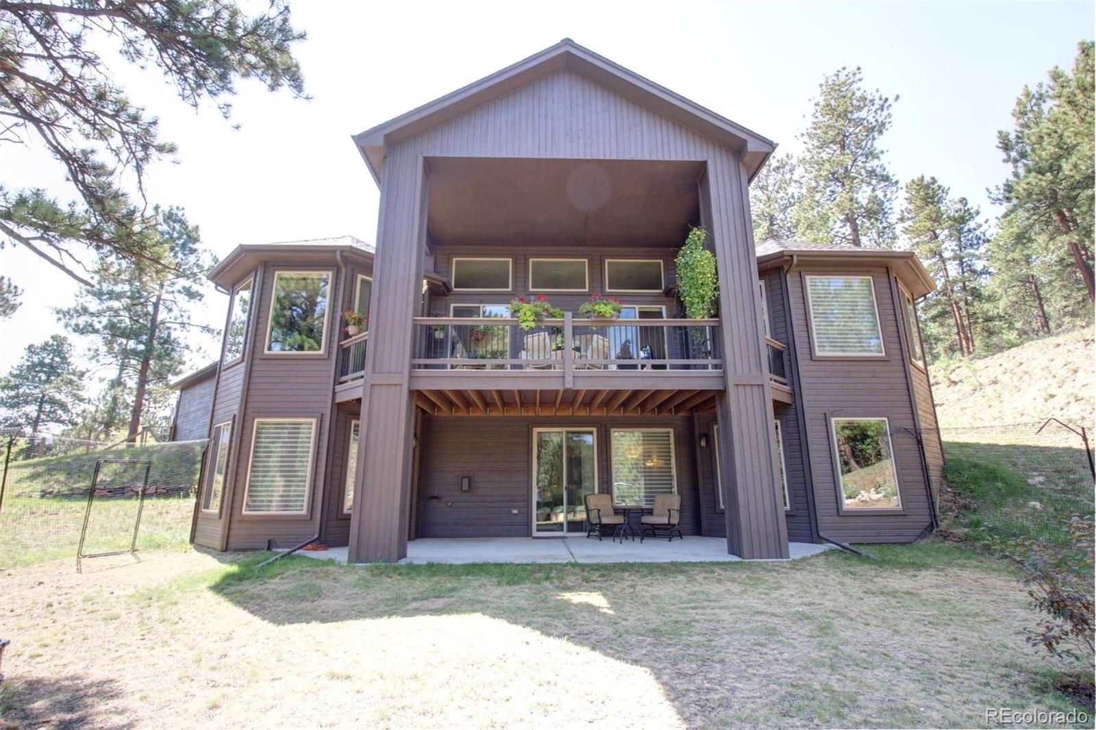 3095 South Piney Ridge Road Evergreen, CO 80439 - Photo 29 of 30 a front view of a house with a yard and garage