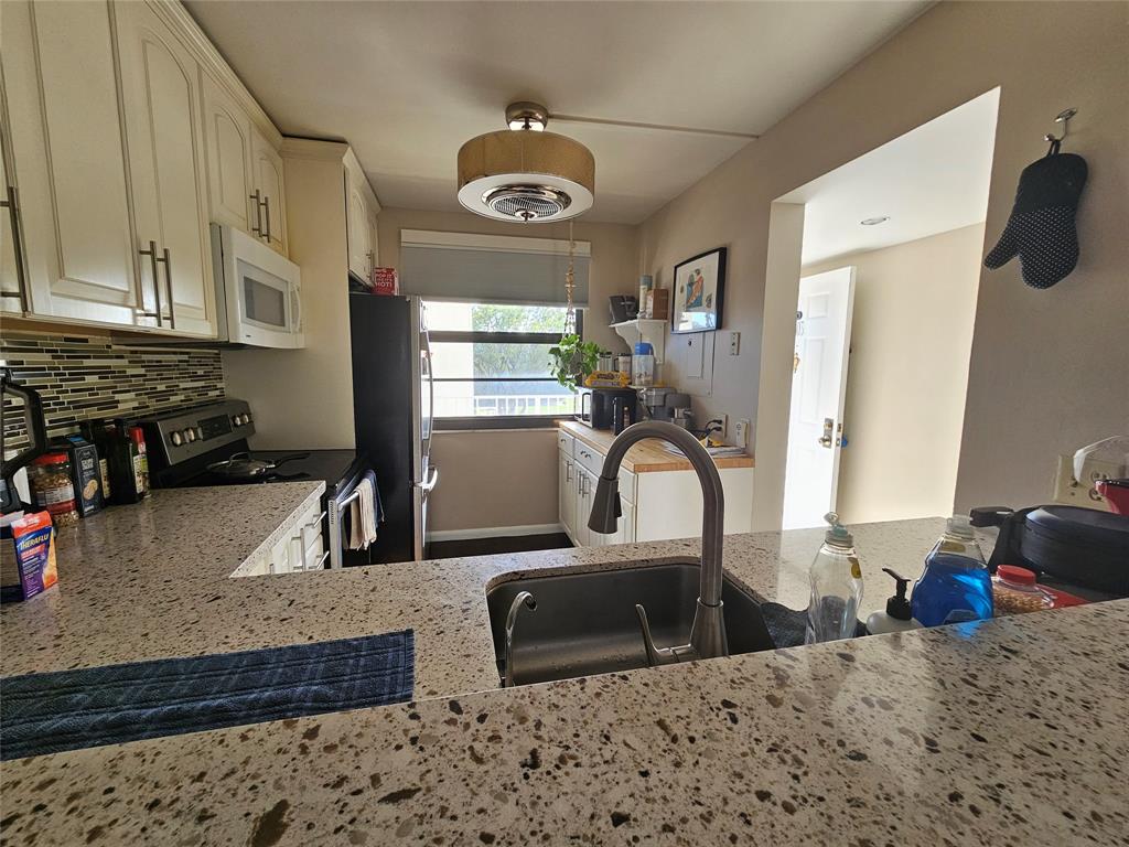 a kitchen with stainless steel appliances granite countertop a sink a stove and a refrigerator