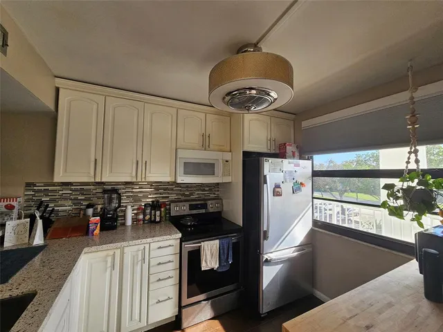 a kitchen with stainless steel appliances granite countertop a stove a refrigerator a sink and a stove