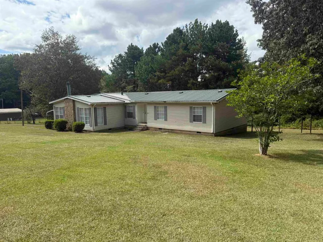 a white house that has a tree in front of it