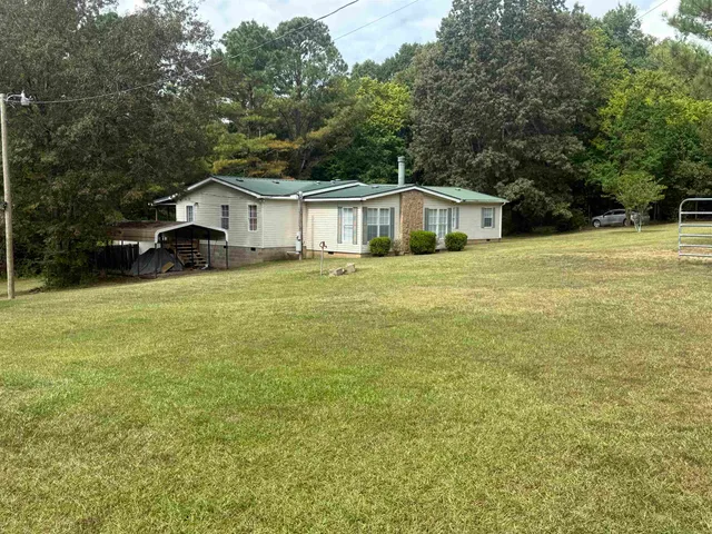a front view of a house with yard and green space