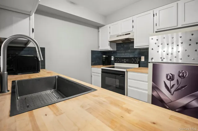 a kitchen with granite countertop a stove and a microwave