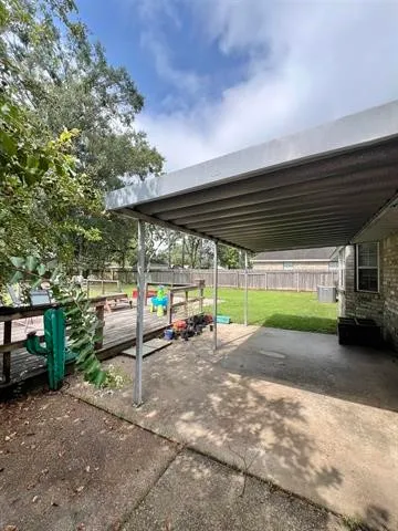 a view of a swimming pool with a yard and large trees