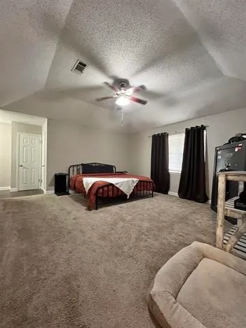 a bedroom with a bed window and dresser