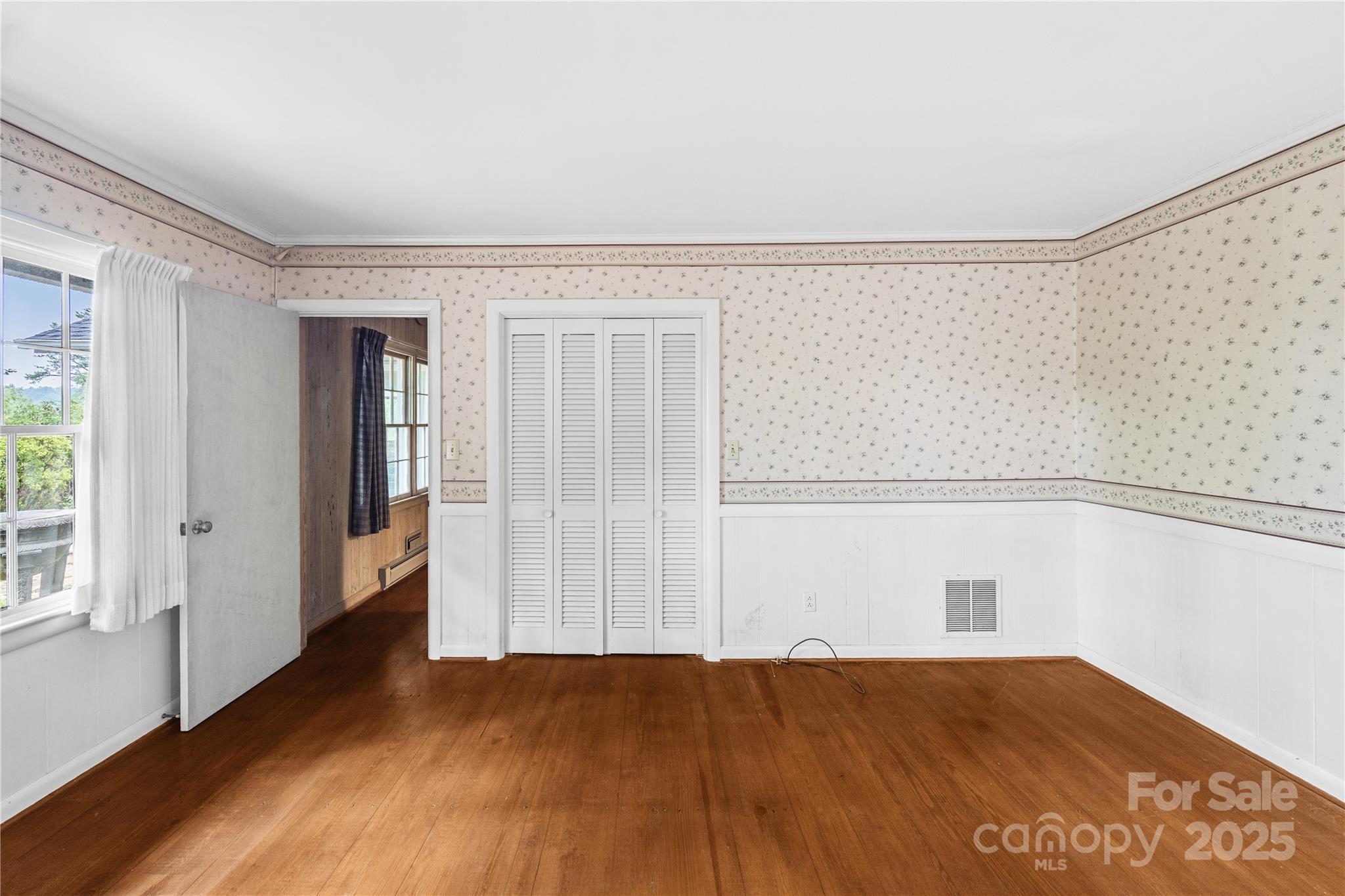 603 Green Hills Road Mill Spring, NC 28756 - Photo 13 of 47 an empty room with wooden floor and windows