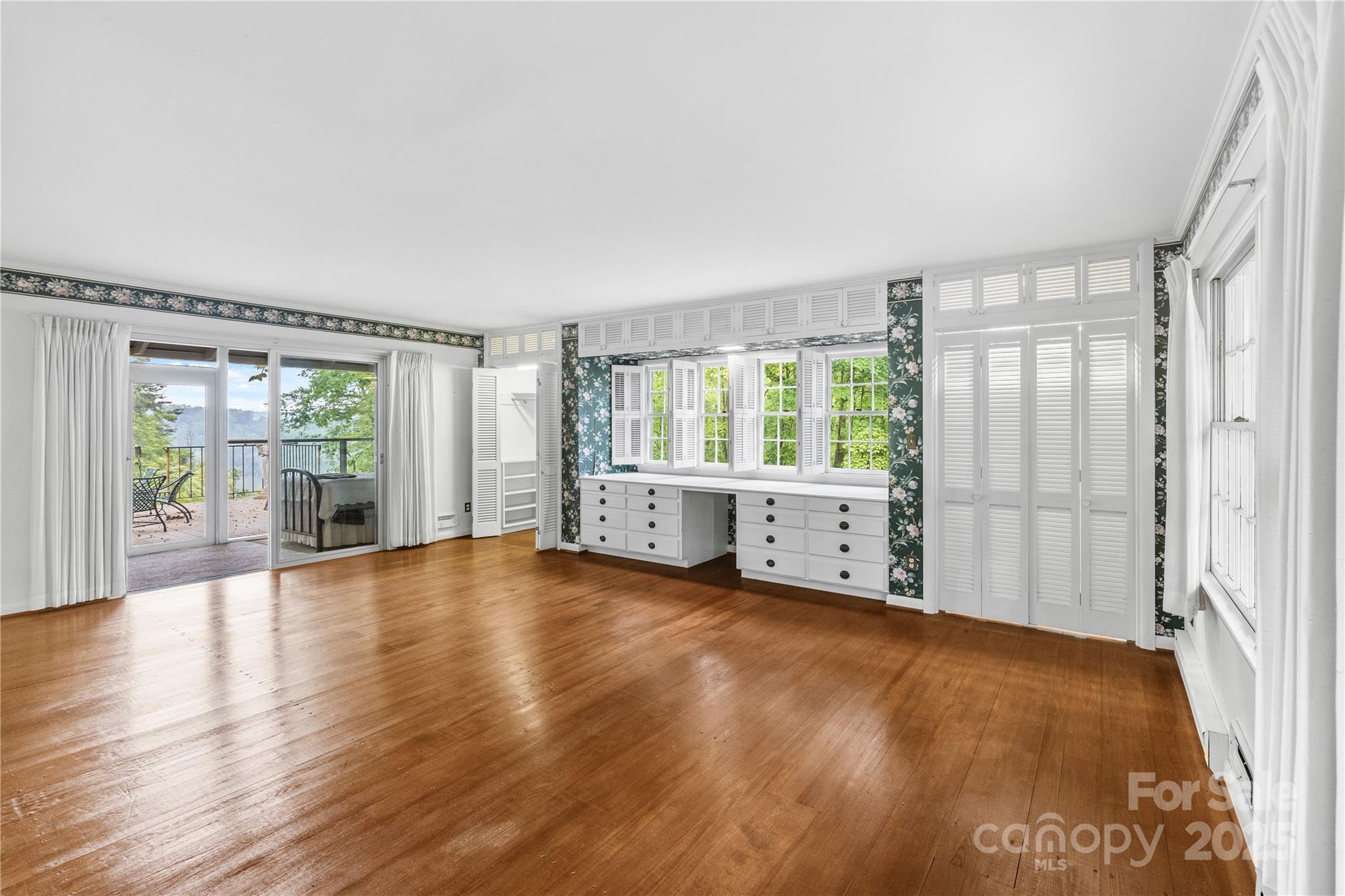 603 Green Hills Road Mill Spring, NC 28756 - Photo 27 of 47 an empty room with wooden floor and windows