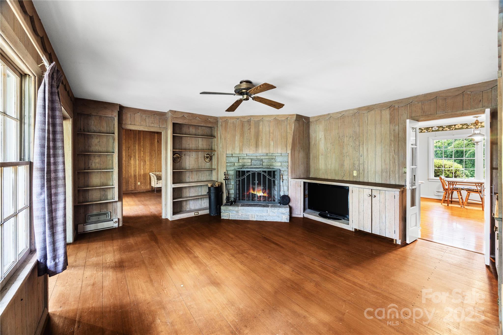 603 Green Hills Road Mill Spring, NC 28756 - Photo 4 of 47 a view of a livingroom with a fireplace a ceiling fan and window