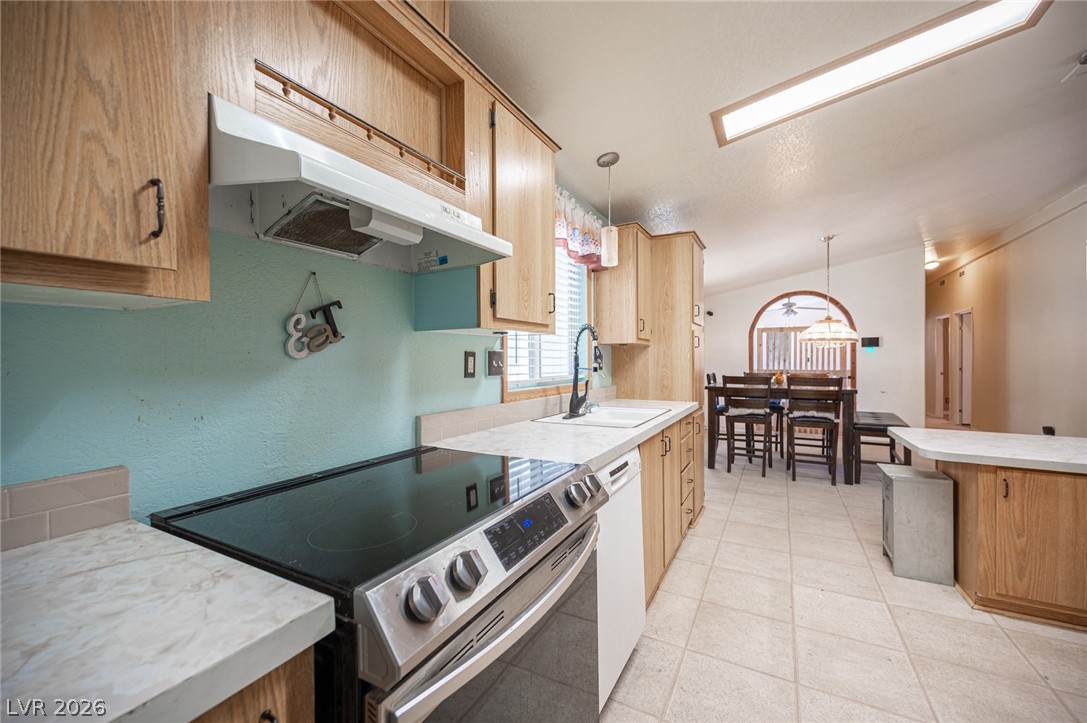 3200 Maple Road Pahrump, NV 89048 - Photo 20 of 53 A well-equipped kitchen boasts a stainless steel range and ample wood cabinetry, seamlessly connecting to a dining space.