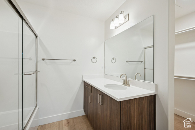 1615 North Angel Street, Unit E Layton, UT 84041 - Photo 24 of 42 Full bathroom featuring light wood-style floors, vanity, and combined bath / shower with glass door