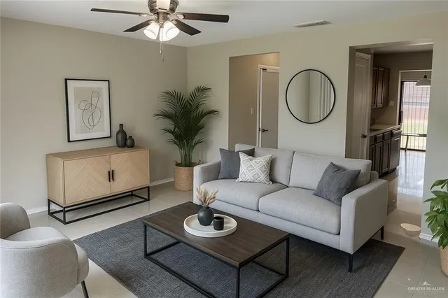 a living room with furniture a rug potted plant and a window