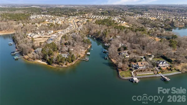 an aerial view of ocean and residential houses with outdoor space