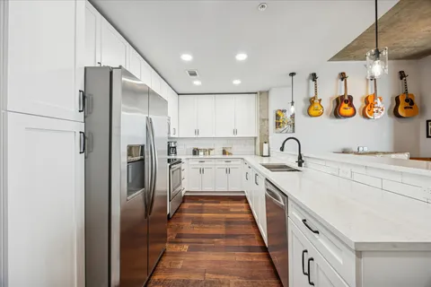 a kitchen with stainless steel appliances granite countertop a sink and refrigerator