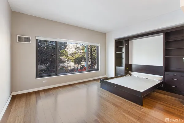 a living room with a large window and a wooden floor