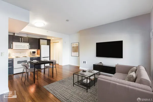 a living room with furniture wooden floor and a flat screen tv