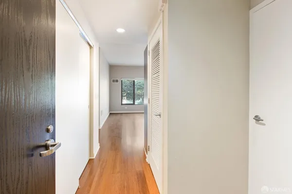 a view of a hallway with wooden floor