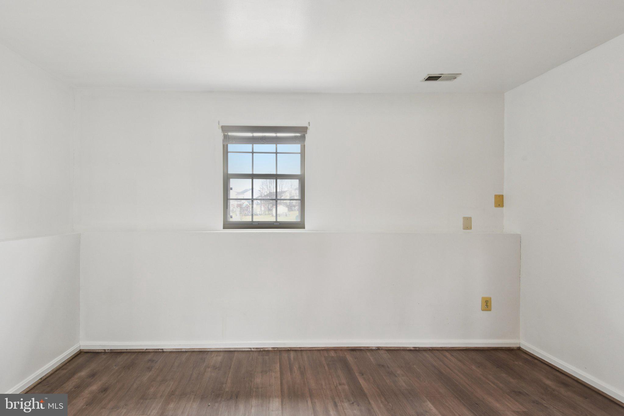 7934 Galloping Circle Windsor Mill, MD 21244 - Photo 19 of 38 an empty room with wooden floor and windows