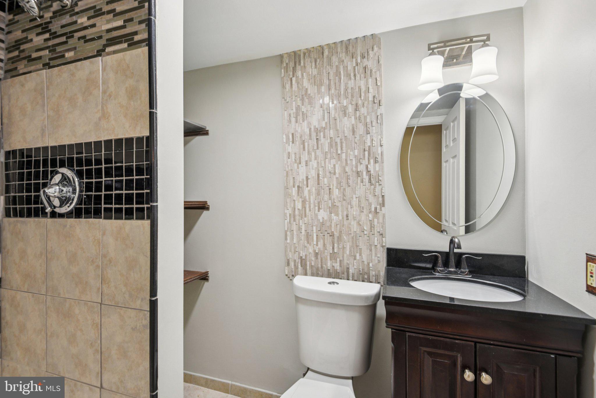 7934 Galloping Circle Windsor Mill, MD 21244 - Photo 21 of 38 a bathroom with a sink a mirror a toilet and shower