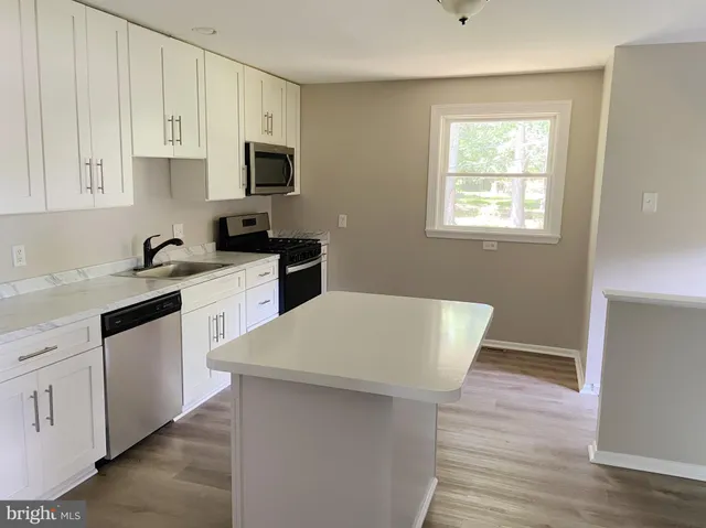 a kitchen with white cabinets appliances and sink