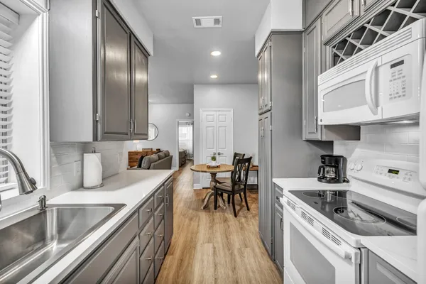 a white stove top oven sitting inside of a kitchen