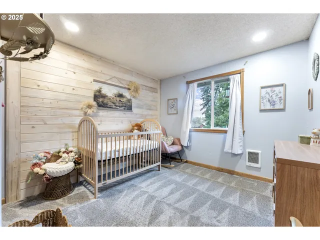 a spacious bedroom with a bed a table and chair