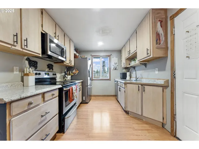 a kitchen with stainless steel appliances granite countertop a stove a sink and a microwave