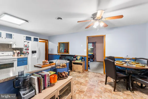 a living room with furniture a dining table and chairs with wooden floor