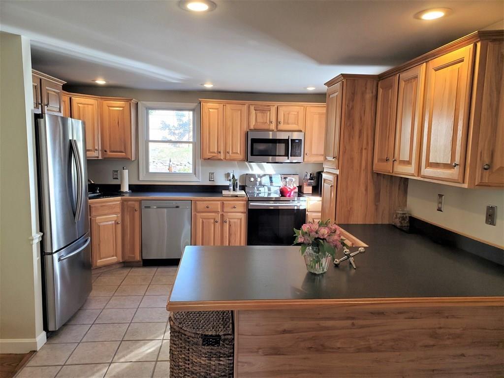 47 Blissful Lane Wareham, MA 02538 - Photo 4 of 24 a kitchen with stainless steel appliances granite countertop a refrigerator a sink dishwasher a stove and white cabinets with wooden floor