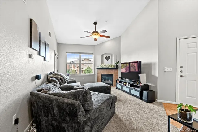 a living room with furniture a fireplace and a flat screen tv