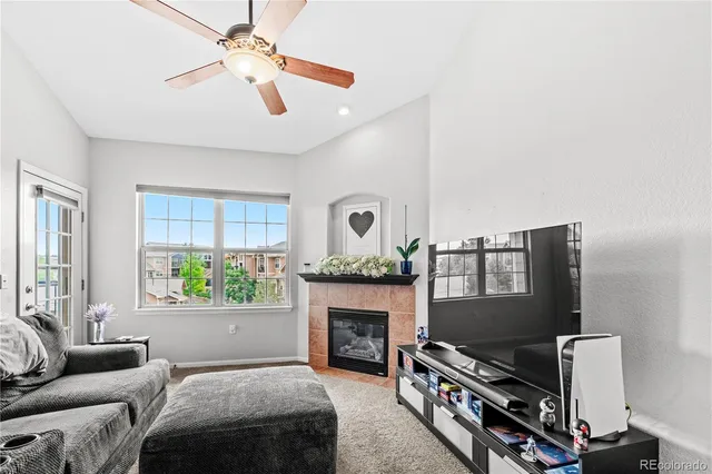a living room with furniture a fireplace and a window