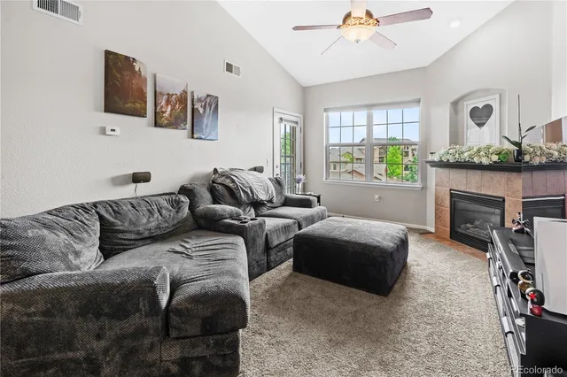 a living room with furniture a fireplace and a chandelier