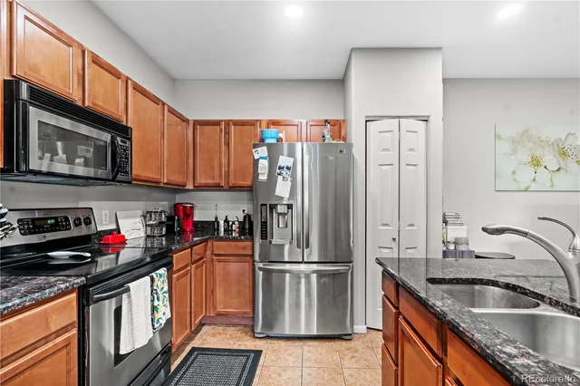 a kitchen with stainless steel appliances granite countertop a refrigerator a sink a stove a microwave and cabinets