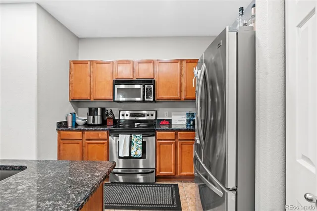 a kitchen with stainless steel appliances granite countertop a stove top oven a sink and dishwasher