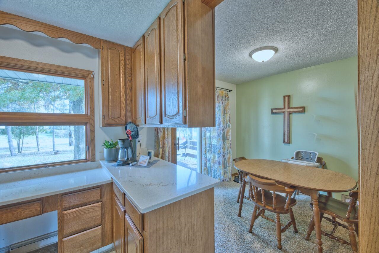 312 South 2nd Street West Aurora, MN 55705 - Photo 11 of 41 Kitchen featuring a textured ceiling, wood finish cabinets, and light stone countertops