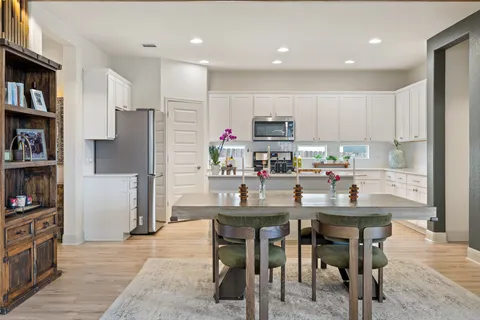 a kitchen with stainless steel appliances kitchen island granite countertop a refrigerator and a stove top oven
