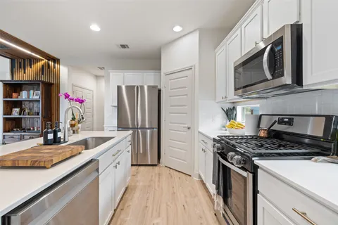a kitchen with stainless steel appliances granite countertop a sink stove and refrigerator