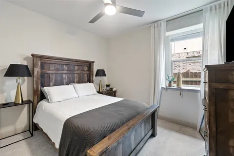 a bedroom with a bed and a refrigerator