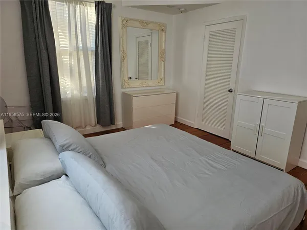 a bedroom with a bed and a window