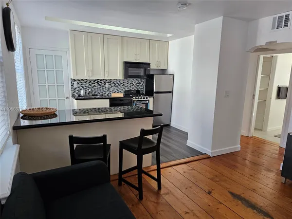 a kitchen with stainless steel appliances granite countertop a refrigerator a stove top oven a sink and dishwasher
