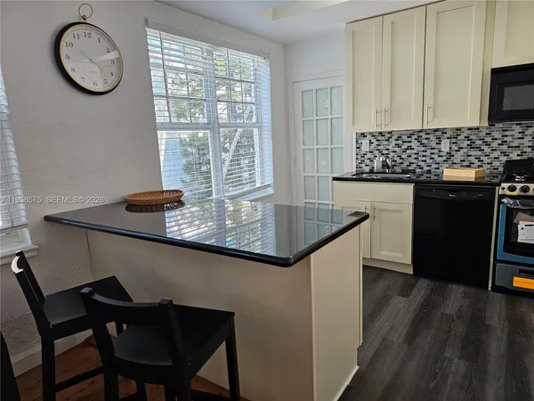 a kitchen with a table chairs and a window