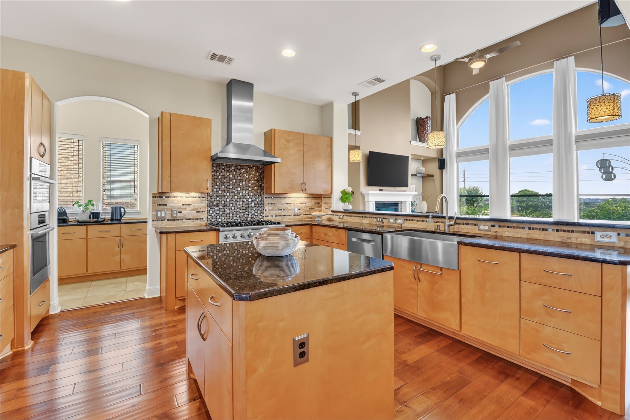 2000 Rio Mesa Drive Austin, TX 78732 - Photo 17 of 39 The kitchen features hardwood flooring, a central island with a granite countertop, and light wood cabinetry