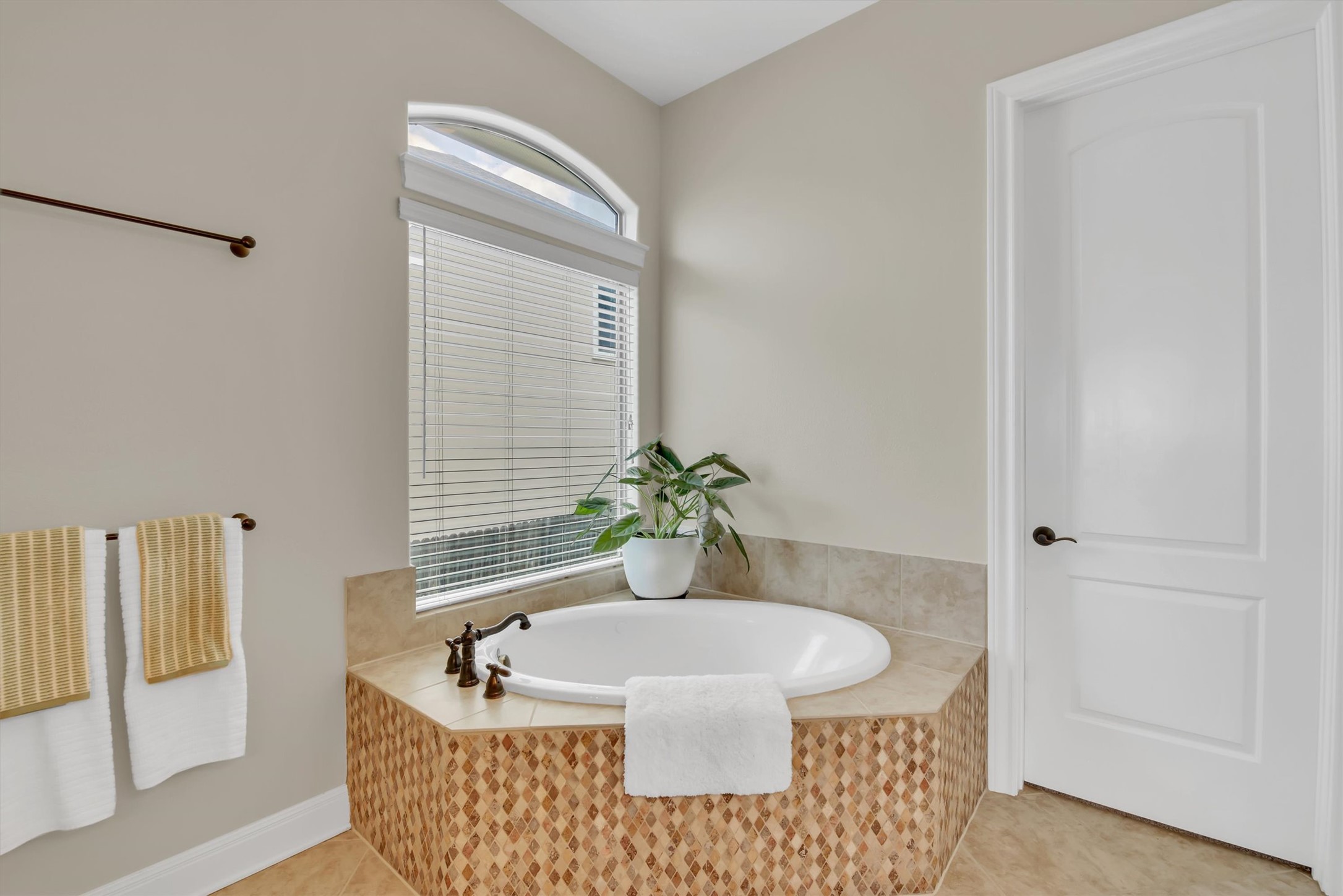 2000 Rio Mesa Drive Austin, TX 78732 - Photo 22 of 39 The bathroom features an inviting built-in bathtub with a tiled surround and a window with blinds providing natural light